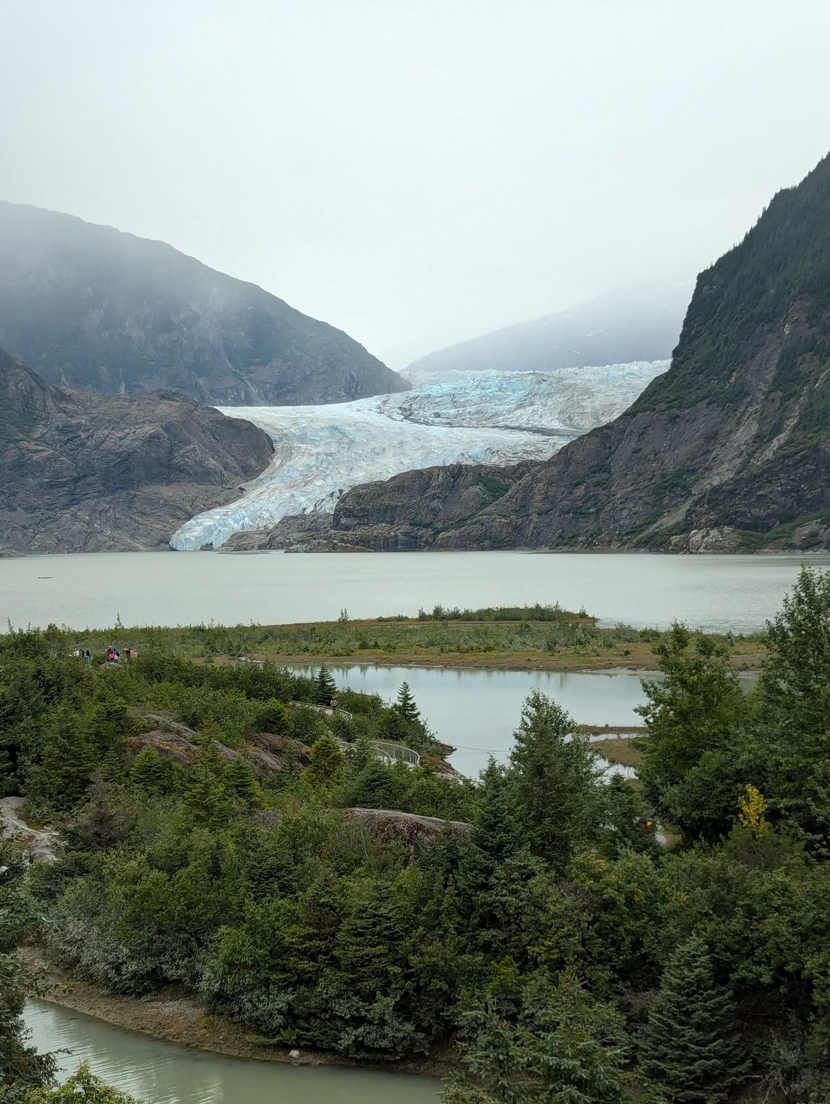 Mendenhall Glacier flowing into its lake under low mist