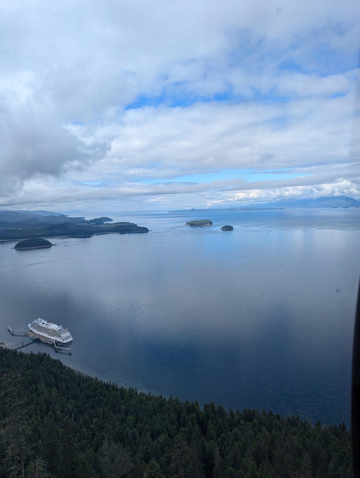 A cruise ship docked at a forested pier at Icy Strait Point, seen from above